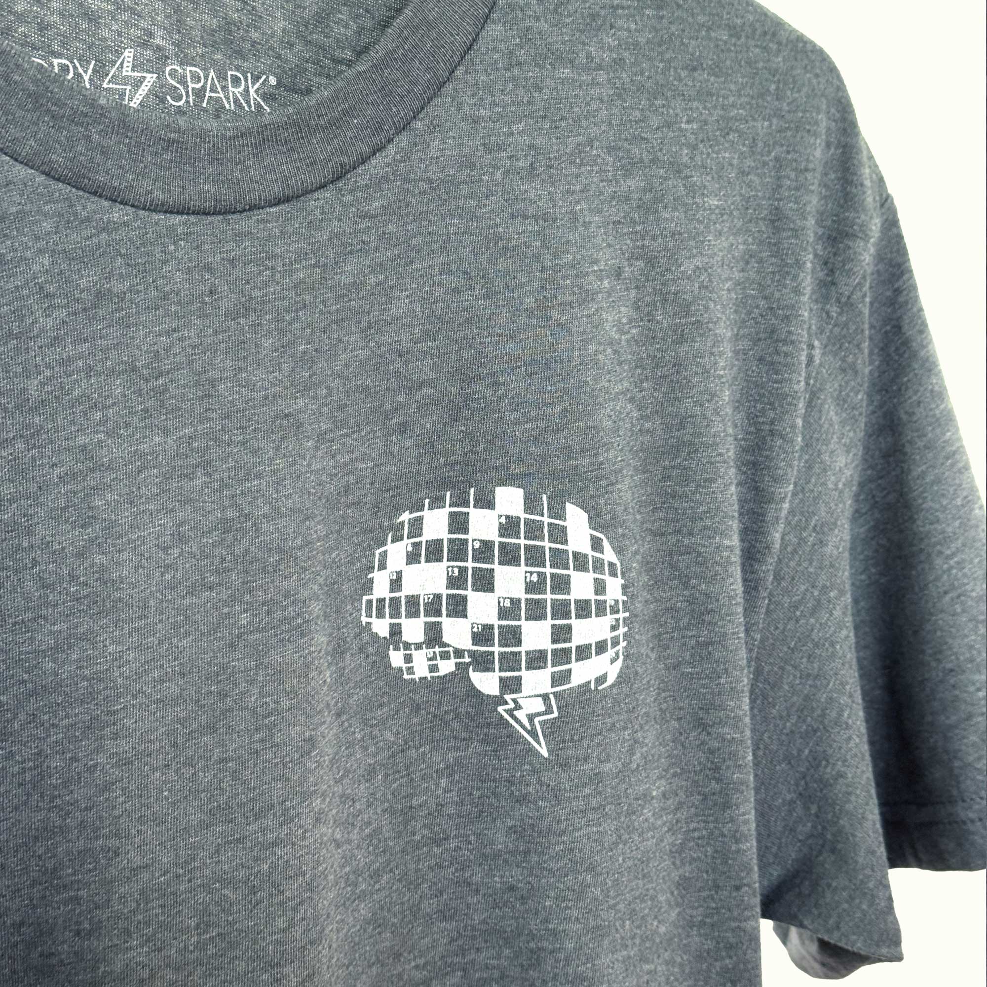 Gray t-shirt with a white crossword puzzle brain design screen printed on the upper left chest