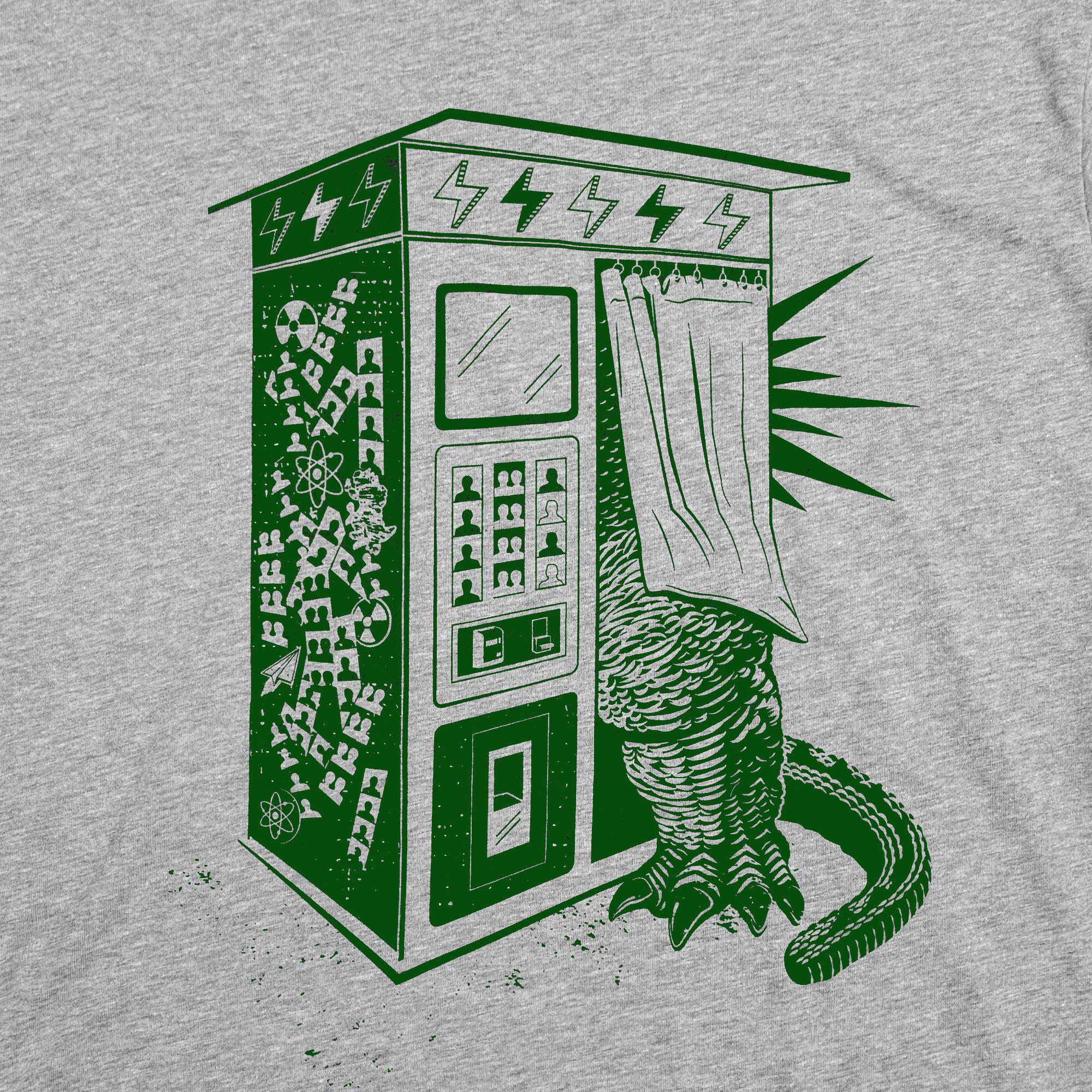 Green photo booth with a creature emerging from it on a gray t-shirt.