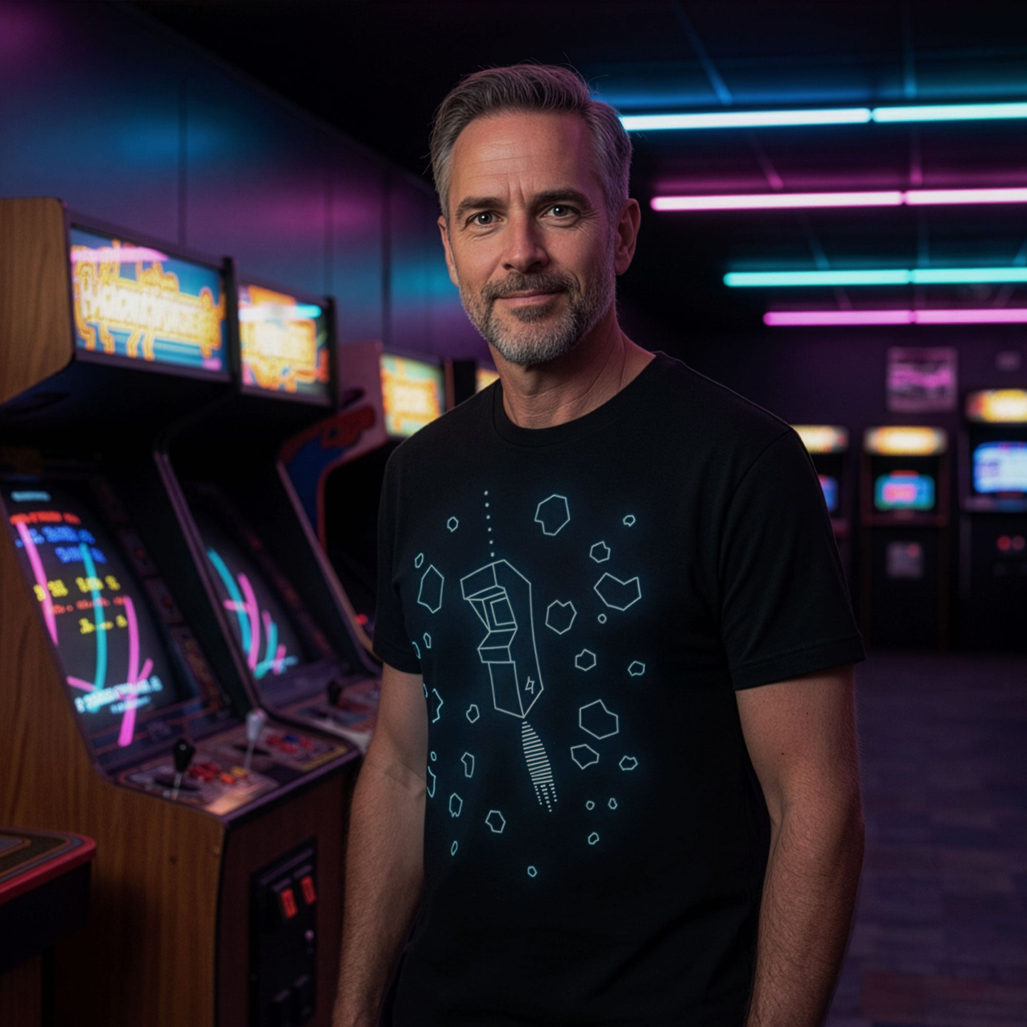 Man standing in front of vintage arcade machines and wearing Outplay retro gamer graphic t-shirt by STORY SPARK
