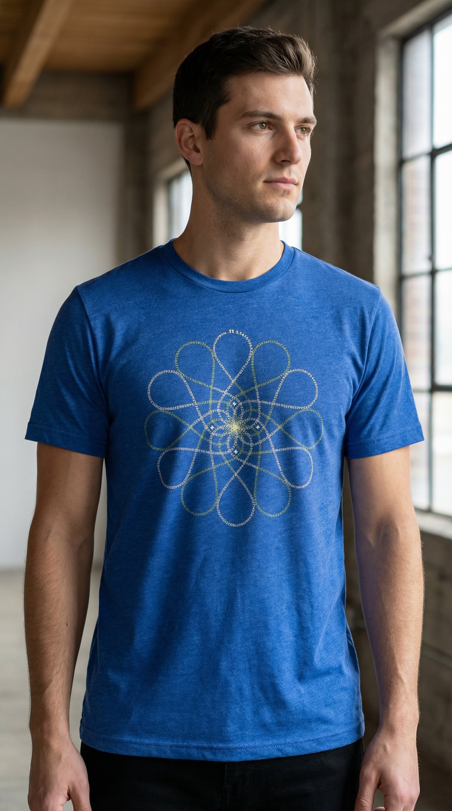 Man wearing a blue Pi day t-shirt with a geometric design in a room with large windows.
